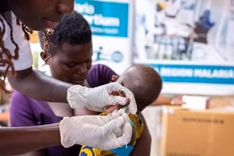 Nhân viên y tế tiêm vaccine phòng sốt rét cho em nhỏ tại Apac, Uganda. (Ảnh: THX/TTXVN)