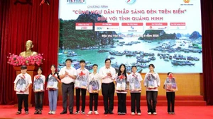 Lãnh đạo tỉnh Quảng Ninh và Báo Pháp luật Thành phố Hồ Chí Minh trao tặng quà cho các cháu học sinh vượt khó học giỏi.