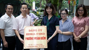 Các lãnh đạo, cán bộ chụp ảnh lưu niệm cùng biển tên mới của trụ sở Đảng ủy-Hội đồng nhân dân-Ủy ban nhân dân phường Hoàn Kiếm.