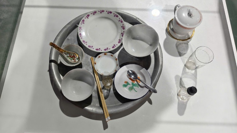 Bộ đồ ăn Chủ tịch Hồ Chí Minh dùng trong thời gian sống và làm việc tại Phủ Chủ tịch được giới thiệu tại Trưng bày. (Ảnh: Ban tổ chức) hien-vat-310.jpg