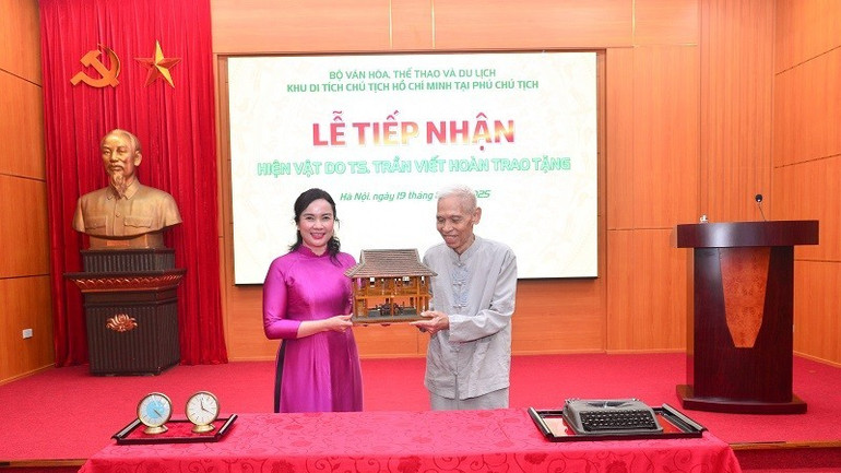 Giám đốc Khu Di tích Phủ Chủ tịch tặng mô hình ngôi Nhà sàn Bác Hồ cho Tiến sĩ Trần Viết Hoàn. (Ảnh: BTC) mo-hinh-3840.jpg