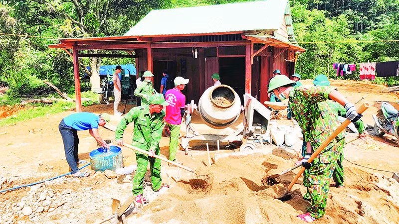 Cán bộ, chiến sĩ Đồn Biên phòng Đắc Pring giúp người dân vùng biên xây dựng nhà mới.