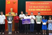 Các đại biểu trao quà cho gia đình chính sách và học bổng cho con em gia đình chính sách tại Quảng Bình.