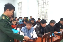 Cán bộ Đồn Biên phòng Làng Ho (Quảng Bình) cấp phát tài liệu kiến thức pháp luật cho bà con Bru-Vân Kiều 
