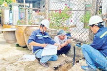 Nhân viên Xí nghiệp cấp nước Cần Giờ gắn đồng hồ nước thông minh thay cho đồng hồ cũ cho các hộ dân tại xã Tam Thôn Hiệp, huyện Cần Giờ.