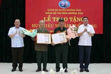 Đồng chí Trần Quốc Cường, Bí thư Tỉnh ủy Điện Biên và đồng chí Mùa A Sơn, Phó Bí thư Thường trực Tỉnh ủy Điện Biên tặng hoa, chúc mừng 2 chiến sĩ Điện Biên vinh dự được nhận Huy hiệu 70 năm tuổi Đảng.