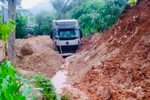 Xe đầu kéo bị đất đá vùi lấp tại đường tỉnh 164. (Ảnh: THANH SƠN)