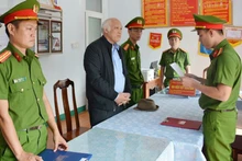 Công an tống đạt các quyết định đối với đối tượng Xa Văn Công. (Ảnh: CTV).