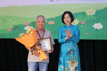 Tổng Giám đốc Thông tấn xã Việt Nam Vũ Việt Trang trao giải Hiệp sĩ Dế Mèn cho nhà văn Trần Đức Tiến. (Ảnh: Ban tổ chức)