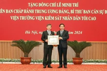 Đồng chí Nguyễn Văn Thể, Bí thư Đảng ủy Khối các Cơ quan Trung ương trao Huy hiệu 40 năm tuổi Đảng và tặng hoa chúc mừng đồng chí Lê Minh Trí, Viện trưởng Viện Kiểm sát nhân dân tối cao.