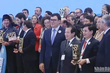 Chủ tịch UBND xã Tân Hóa nhận Giải thưởng “Làng du lịch tốt nhất” của UNWTO với sự chúc mừng của Phó Cục trưởng Hà Văn Siêu và Tổng Thư ký UNWTO Zurab Pololikashvili. (Ảnh chụp từ clip của UNWTO) 