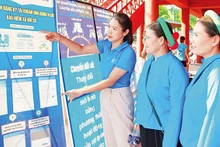 Cán bộ Bảo hiểm xã hội Quảng Ninh giới thiệu về bảo hiểm xã hội số tới người dân. (Ảnh QUANG THỌ)