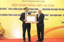 Đồng chí Đỗ Văn Chiến trao Huân chương Lao động hạng Ba tặng ông Phạm Xuân Trường, Ủy viên Ban Thường vụ Hội Người mù Việt Nam, với những đóng góp vì người mù. (Ảnh: mattran.org.vn)