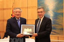 Chánh án Tòa án Nhân dân Tối cao Nguyễn Hòa Bình (trái) tặng quà lưu niệm cho ông Christian Coquoz, Chánh án Tòa án bang Geneva. (Ảnh: TTXVN)