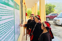 Bà con xã Ngam La tìm hiểu về các chương trình vay vốn tín dụng chính sách được niêm yết công khai tại Điểm giao dịch xã.
