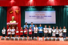 Lãnh đạo Công đoàn Việt Nam và lãnh đạo Công đoàn Báo Nhân Dân tặng quà cho các cháu học sinh có hoàn cảnh khó khăn vươn lên trong học tập của huyện Na Hang, tỉnh Tuyên Quang. 