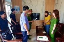 Lực lượng chức năng đọc quyết định tạm giữ hình sự đối tượng Hà Thị Thu Thủy (người mặc áo vàng).