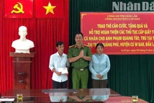 Thượng tá Lê Văn Khánh, Phó Trưởng Công an huyện Cư M'gar trao căn cước công dân và số tiền do cán bộ, chiến sĩ Công an huyện quyên góp tặng cho vợ chồng anh Phạm Quang Tèo.