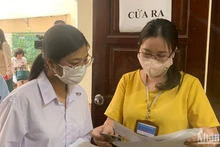 Giám thị gọi thí sinh vào phòng thi theo số báo danh tại điểm thi Trường đại học Sư phạm Hà Nội. (Ảnh: THÚY QUỲNH)
