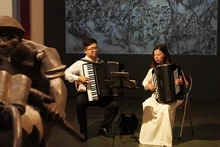 Hai nghệ sĩ accordion Nguyễn Quỳnh Chi và Vũ Việt Hưng biểu diễn trong không gian trưng bày các tác phẩm mỹ thuật về Chiến dịch Điện Biên Phủ tại Bảo tàng Mỹ thuật Việt Nam. (Ảnh: THANH BÌNH) 