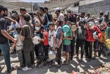 Người dân Palestine chờ nhận thực phẩm cứu trợ tại Deir el-Balah, miền trung Dải Gaza ngày 13/5/2024. Ảnh: AFP/TTXVN