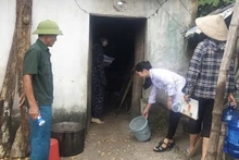 Cán bộ y tế hướng dẫn người dân vệ sinh môi trường sau bão, lụt trên địa bàn huyện Ứng Hòa, Hà Nội.