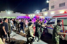 Binh sĩ và lực lượng phản ứng nhanh Iraq chuyển các nạn nhân vụ hỏa hoạn trong đám cưới tới bệnh viện Hamdaniyah ở Al-Hamdaniyah, Iraq ngày 27/9. (Ảnh: AFP/TTXVN)
