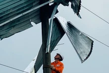 Công nhân Điện lực Bát Xát (Lào Cai) gỡ mái tôn khỏi cột điện.
