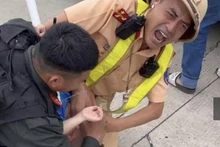 Đại úy Bùi Chí Công nén đau ngăn cản việc cháu bé cắn răng vào lưỡi.
