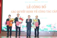 Chánh án Tòa án nhân dân tối cao Lê Minh Trí trao quyết định và tặng hoa chúc mừng các đồng chí được bổ nhiệm.
