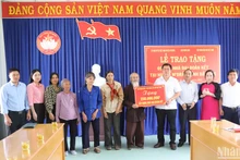 Đại diện Báo Nhân Dân trao bảng tượng trưng số tiền 250 triệu đồng tặng 5 gia đình, mỗi gia đình 50 triệu đồng để xây dựng nhà đại đoàn kết.