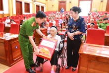 Đại tá Đỗ Tiến Thùy, Phó Giám đốc Công an tỉnh Tuyên Quang tặng quà Mẹ Việt Nam Anh hùng, mẹ liệt sĩ tham gia lấy mẫu.