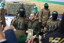 Lữ đoàn Al-Qassam, một cánh quân của Phong trào Hamas, trao trả con tin Israel cho Ủy ban Chữ thập đỏ quốc tế tại trại tị nạn Nuseirat ở miền trung Dải Gaza, ngày 22/2/2025. (Ảnh: THX/TTXVN)