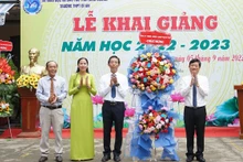 Chủ tịch UBND tỉnh Bình Dương Võ Văn Minh (bên phải) trao tặng hoa, chúc mừng khai giảng tại Trường THPT Dĩ An, thành phố Dĩ An, tỉnh Bình Dương. 