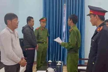 Công an tống đạt quyết định khởi tố bị can đối với ông Võ Hữu Dũng (bìa trái) và ông Lê Văn Được.