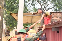 Hỗ trợ người dân đang bị nước lũ cô lập tại xã Hòa Tiến, huyện Yên Phong.