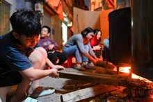 Người lớn, trẻ nhỏ quây quần, thức xuyên đêm trong nhiều con ngõ tại Hà Nội canh nồi bánh chưng Tết.