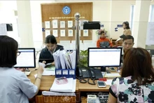 Giải quyết thủ tục hành chính tại bảo hiểm xã hội địa phương. (Ảnh: TTXVN)