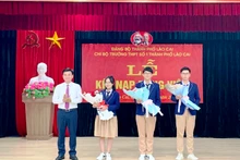 Lãnh đạo Thành ủy Lào Cai tặng hoa chúc mừng 3 đảng viên mới là học sinh Trường Trung học phổ thông số 1 thành phố Lào Cai. (Ảnh: NGUYỄN NHIN) 