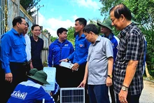 Các chiến sĩ tình nguyện thực hiện lắp trụ đèn chiếu sáng của công trình “Thắp sáng đường quê”.