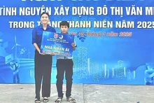 Em Lâm Nguyễn Việt Uyên trao bảng tượng trưng cho em Lý Thiện Đức. (Ảnh: TRUNG THÀNH)