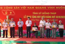 Bí thư Tỉnh ủy Đồng Tháp Lê Quốc Phong trao Huy hiệu Đảng cho các đảng viên. (Ảnh: HỮU NGHĨA)