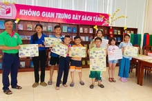 Ông Trần Tuấn Khanh, Phó Trưởng phòng Công tác người đọc, Thư viện tỉnh Đồng Tháp, tặng phụ trương đến bạn đọc trẻ. (Ảnh: Thư viện tỉnh Đồng Tháp)