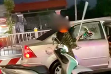 Bà T.T.B.L dùng 1 thanh kim loại đập vỡ kính và chèn ép 1 xe ô-tô đang chạy. (Ảnh: Công an cung cấp)