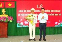 Ủy viên Trung ương Đảng, Bí thư Tỉnh ủy Đồng Tháp Lê Quốc Phong trao Huy hiệu 40 năm tuổi Đảng và tặng hoa chúc mừng Đại tá Nguyễn Văn Hiểu. (Ảnh: Công an cung cấp)