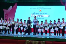 Ủy viên Trung ương Đảng, Bí thư Tỉnh ủy Đồng Tháp Lê Quốc Phong và bà Katsumata Jitsuko - Tổng Giám đốc điều hành Công ty Fujiko Production trao học bổng cho học sinh. (Ảnh: HỮU NGHĨA)