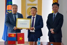Ông Phạm Quyết Tiến, đại diện cộng đồng người Việt Nam tại Mông Cổ trao khoản tiền quyên góp cho Tổng Cục trưởng NEMA Mông Cổ G.Ariunbuyan trước sự chứng kiến của Đại sứ Việt Nam tại Mông Cổ Doãn Khánh Tâm. (Ảnh: Đại sứ quán Việt Nam tại Mông Cổ)