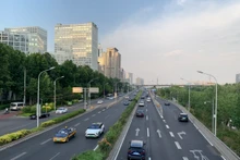 Ô-tô di chuyển trên đường phố Bắc Kinh. (Ảnh: HỮU HƯNG)