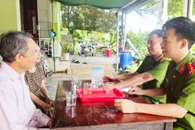 Thượng úy Nguyễn Đăng Thiện cùng đồng đội trao đổi với ông Lê Dục về kết quả mô hình phòng ngừa, giáo dục người chưa thành niên vi phạm pháp luật. 