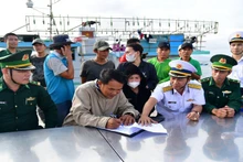Bàn giao tàu cá BĐ 98833TS cùng 14 ngư dân cho cơ quan chức năng. (Ảnh: NGUYỄN NAM)